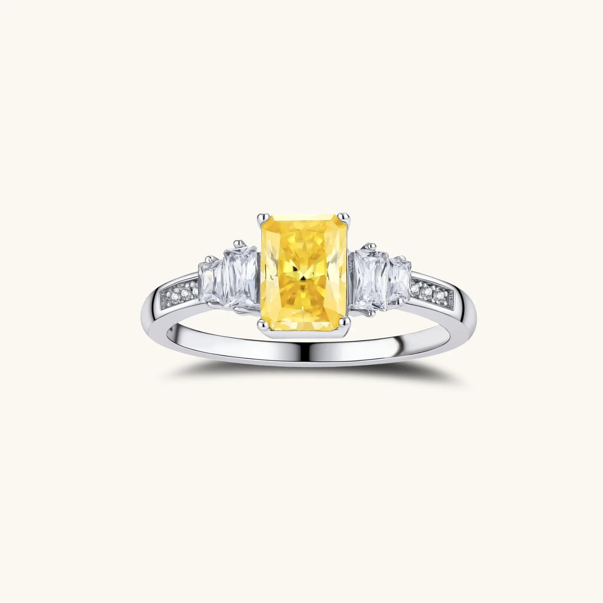 yellow moissanite jewelry set with emerald-cut stones in sterling silver halo settings on white background.