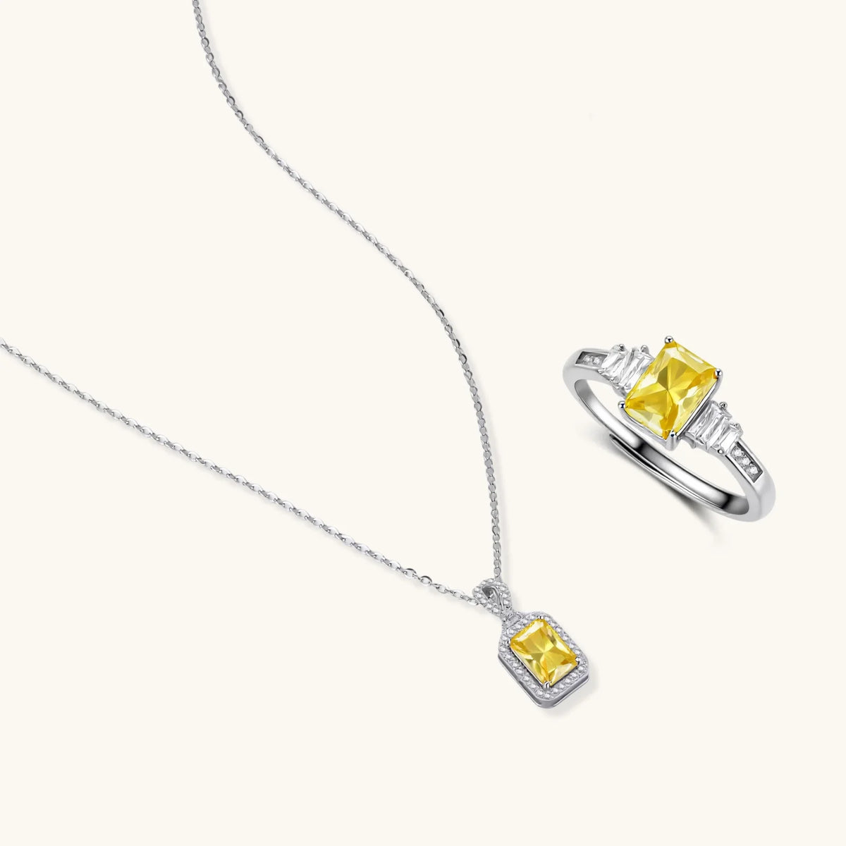 yellow moissanite jewelry set with emerald-cut stones in sterling silver halo settings on white background.
