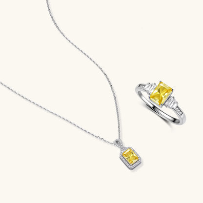 Yellow moissanite jewelry set with emerald-cut stones in sterling silver halo settings on white background.