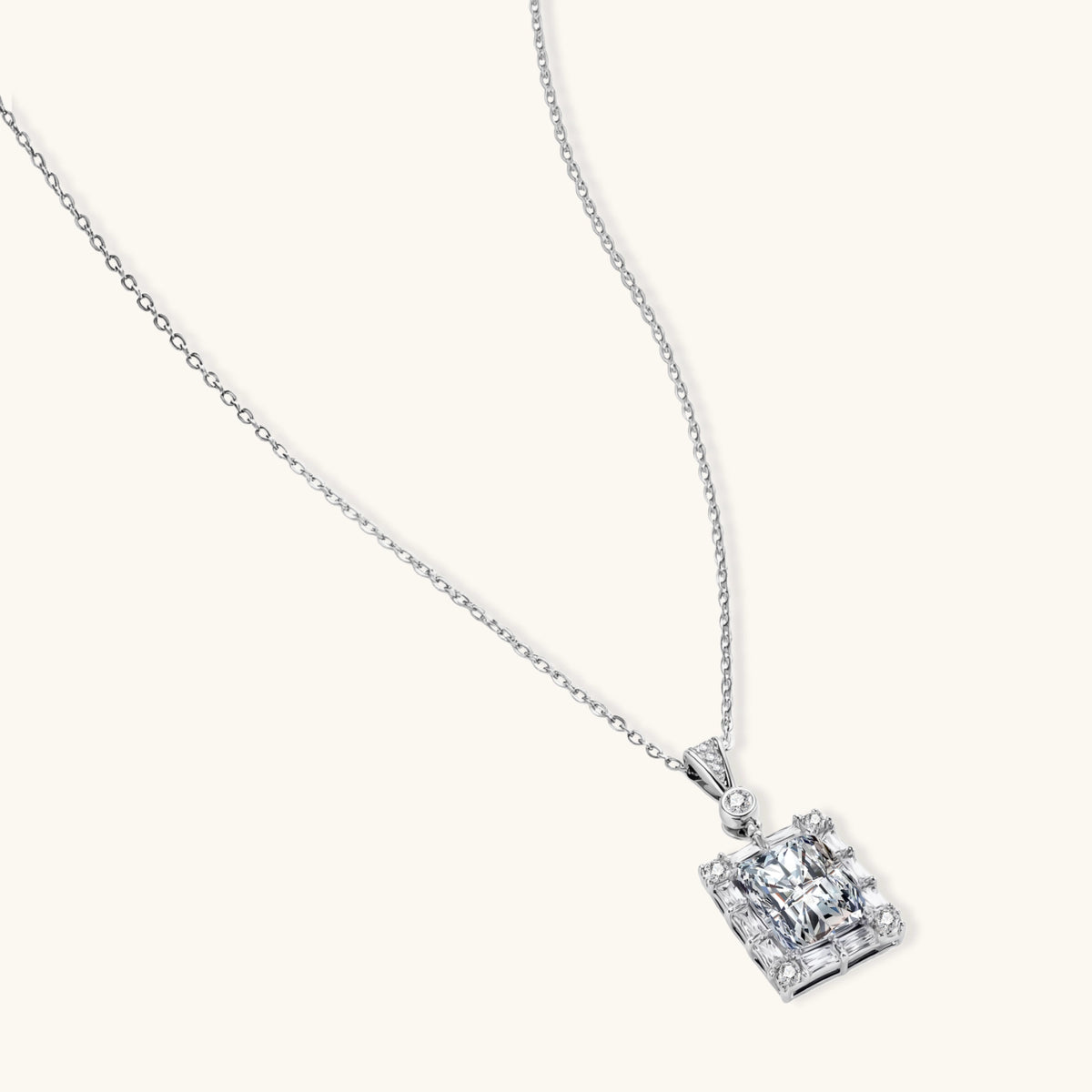 square moissanite pendant with halo setting on delicate sterling silver chain against white background.