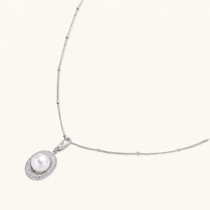 Oval sterling silver pendant with crystal halo surrounding a white freshwater pearl on delicate chain