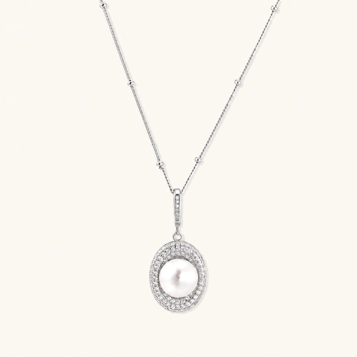 Oval sterling silver pendant with crystal halo surrounding a white freshwater pearl on delicate chain