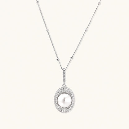 Oval sterling silver pendant with crystal halo surrounding a white freshwater pearl on delicate chain