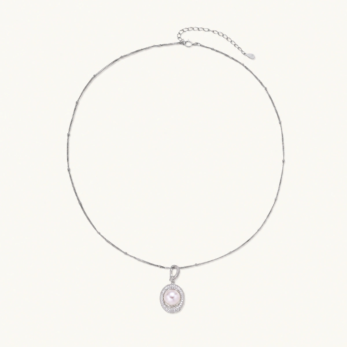 Oval sterling silver pendant with crystal halo surrounding a white freshwater pearl on delicate chain