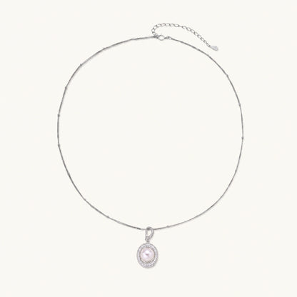 Oval sterling silver pendant with crystal halo surrounding a white freshwater pearl on delicate chain