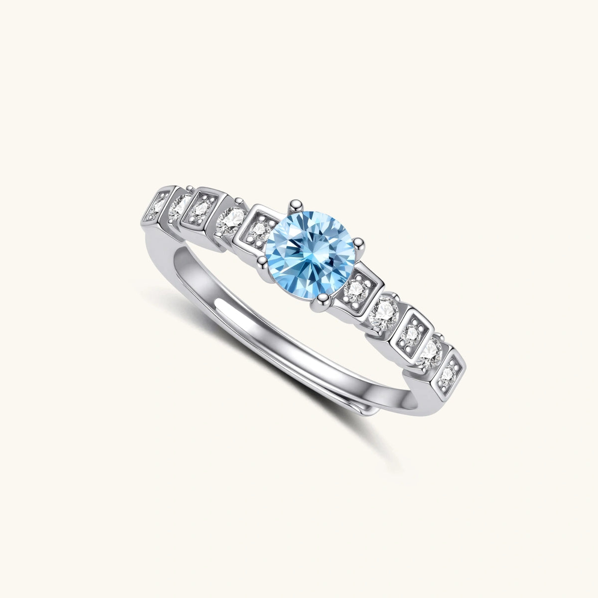 geometric sterling silver ring with light blue moissanite center stone and square diamond accents on white background