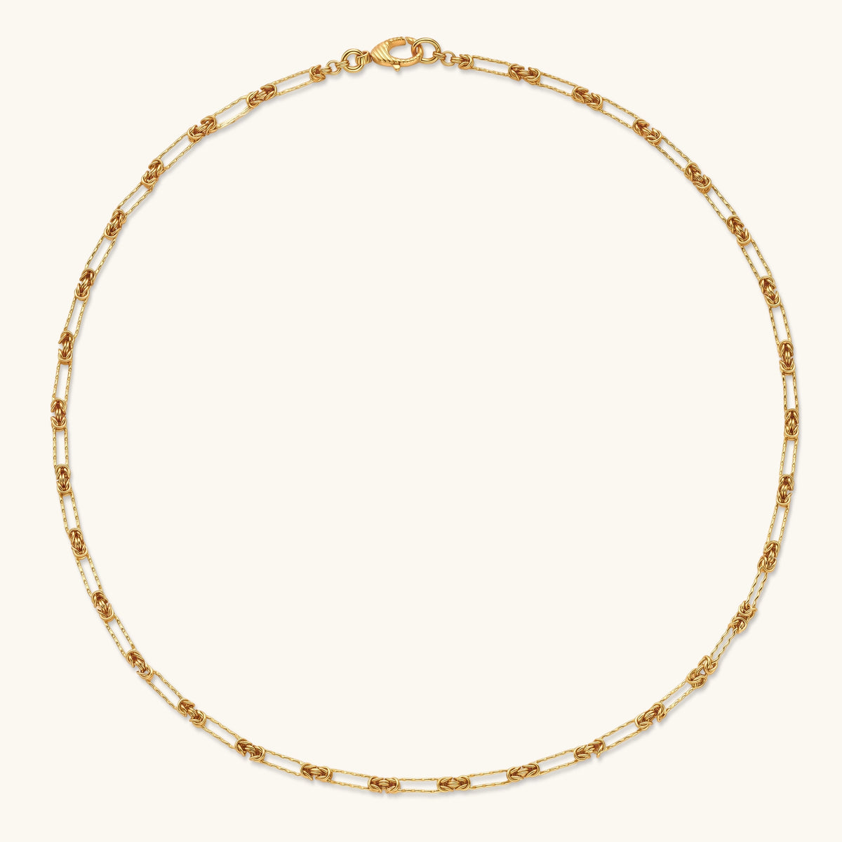 Gold-plated sterling silver chain necklace with alternating love-knot links and elongated oval links, lobster clasp closure.